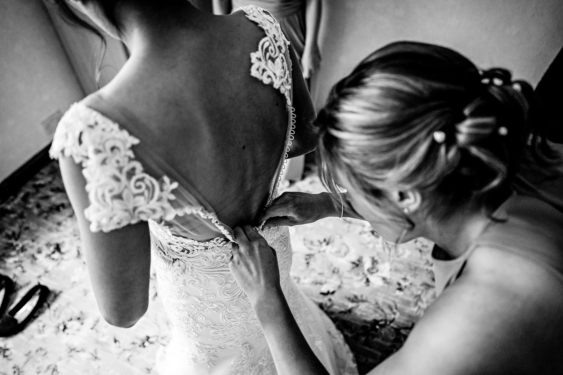 bride having her dress buttoned up